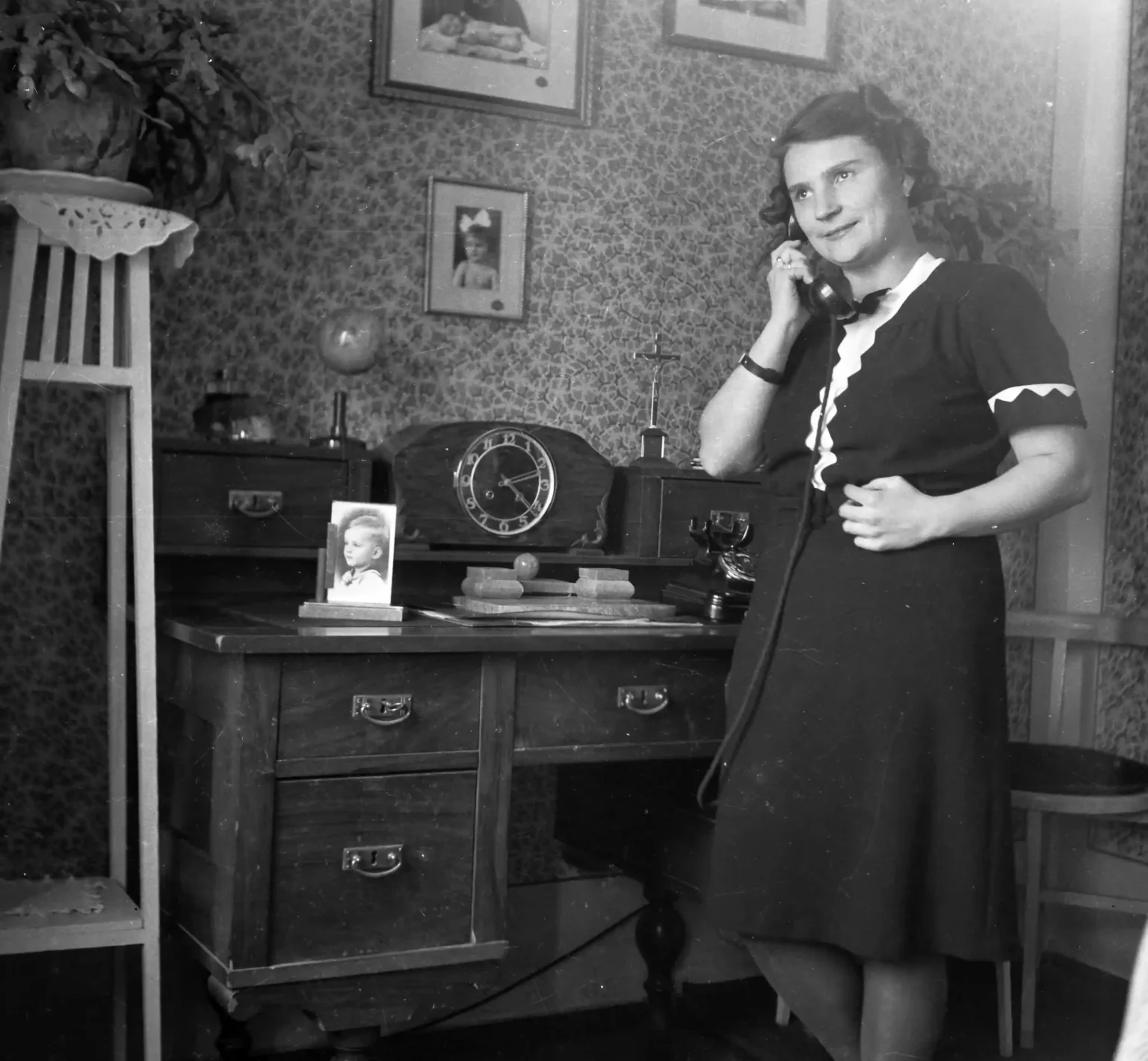 Fiatal nő telefonál egy régi nappaliban, archív fotó